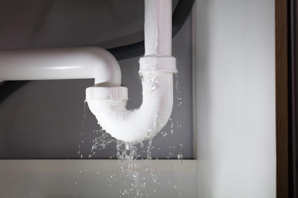 Close-up Of Water Leaking From The White Sink Pipe