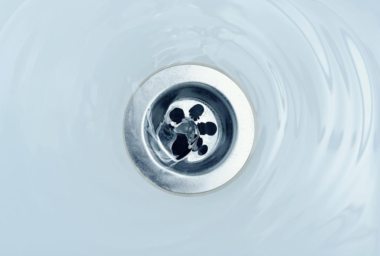 Water flows down drain in bath