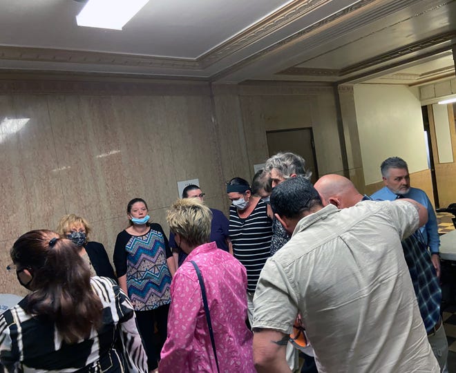 Robert Allen's family and friends pray outside the western courtroom of the Grayson County Courthouse on Tuesday as the man charged with Allen's murder got underway.