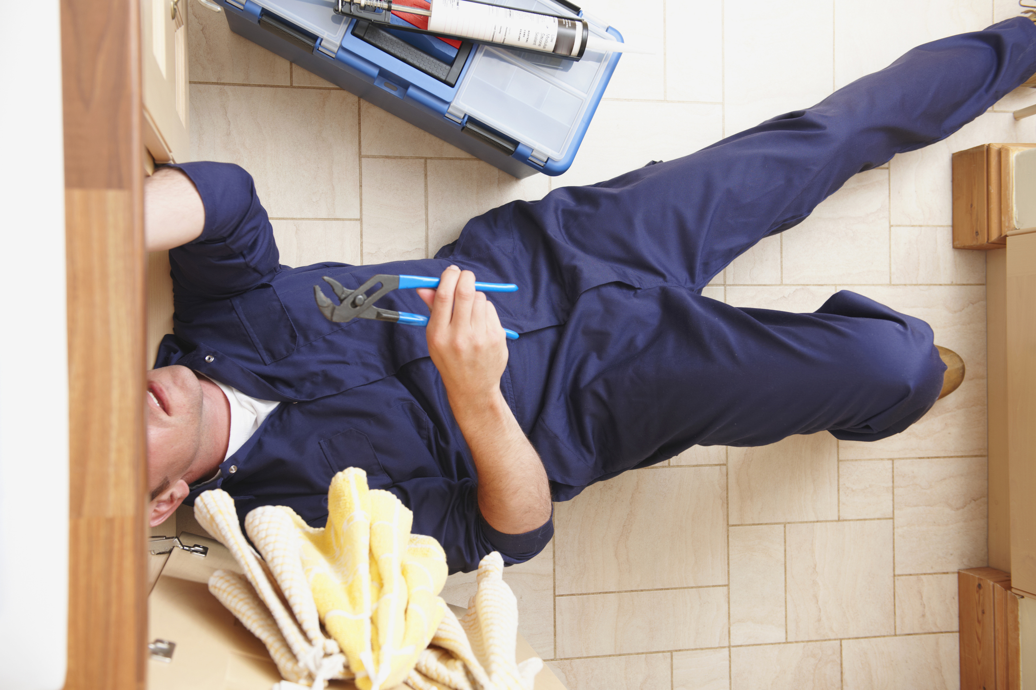 Top view of Caucasian plumber repairing sink