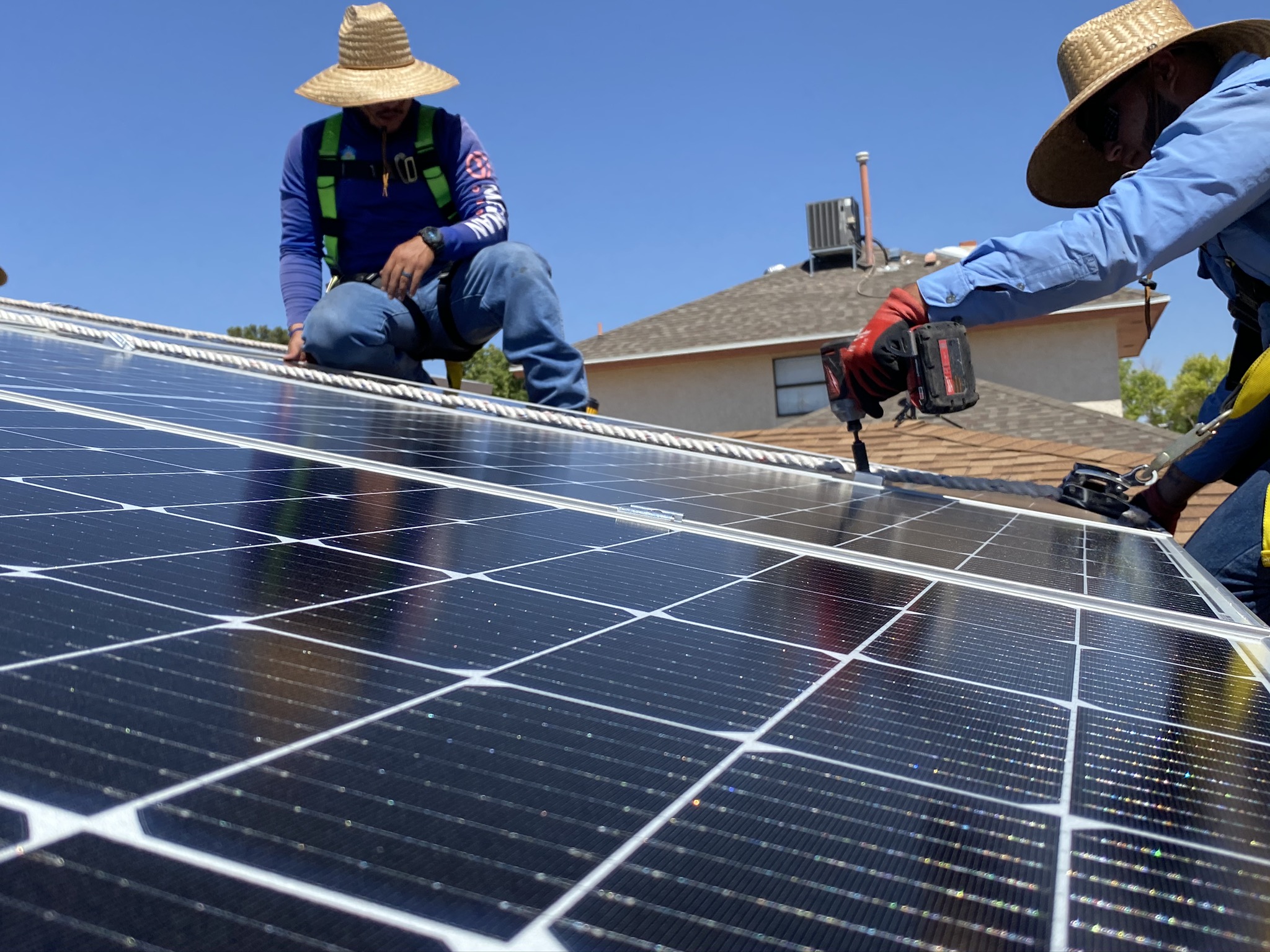 Solar Smart Living Solar Smart Living installers work on a residential rooftop.