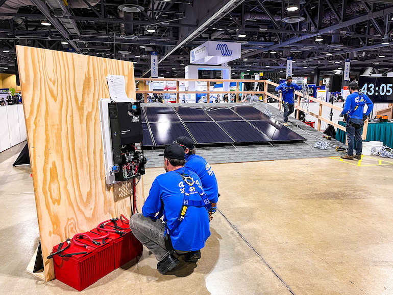Solar Games midnite Hybrid inverter copy Installers connect a MidNite Solar hybrid inverter to a battery stack at the 2022 Solar Games.