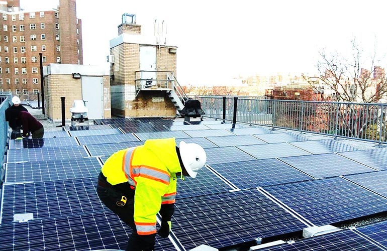 Con-Edison Workers installing solar panels at Carver Houses, a New York City Housing Authority development in northern Manhattan. Photo credit: Accord Power Inc.
